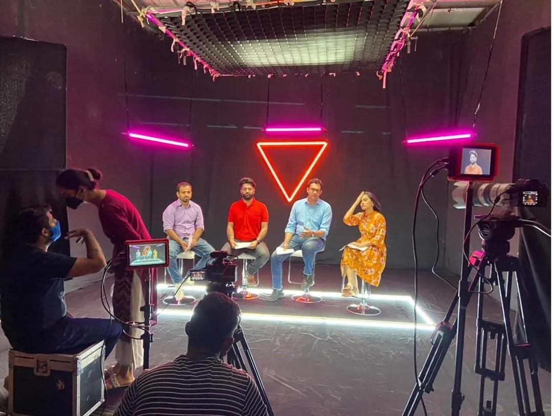 A panel discussion being filmed in a studio